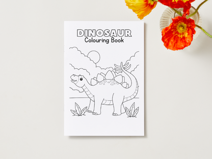 Dinosaur coloring book on a white surface with flowers in the background